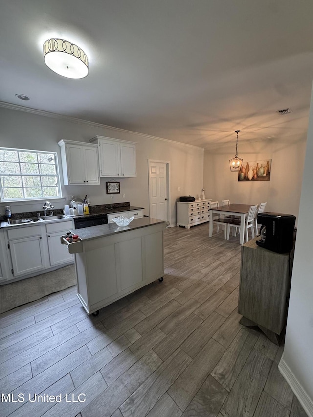 kitchen with visible vents, white cabinets, a kitchen island, wood finished floors, and decorative light fixtures