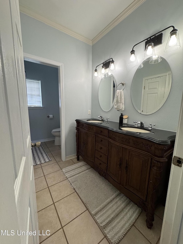 bathroom with toilet, crown molding, a sink, and tile patterned floors