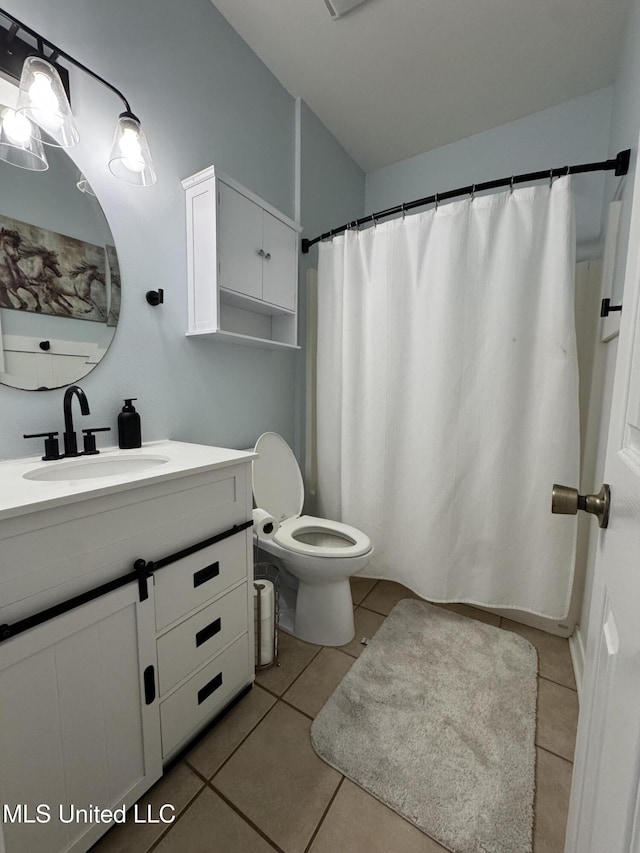 full bath with toilet, vanity, and tile patterned floors