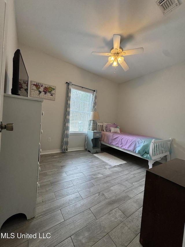 bedroom with visible vents, ceiling fan, baseboards, and wood finished floors