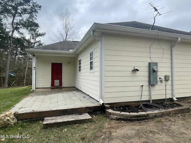 back of house with a patio area and roof with shingles