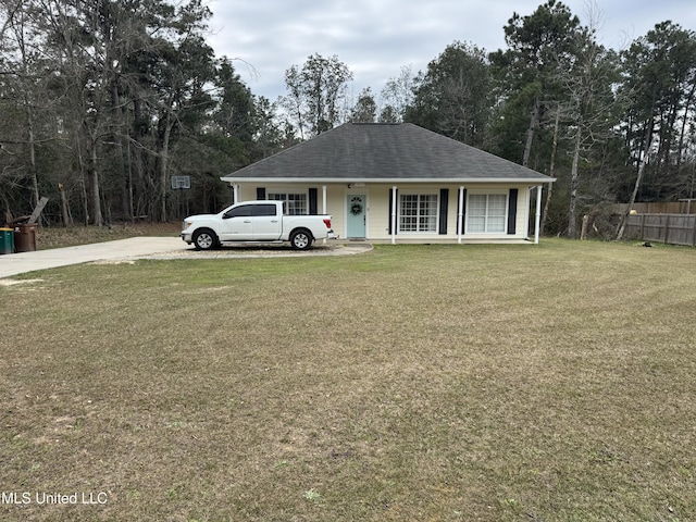 view of front facade featuring covered porch, a front lawn, a shingled roof, and fence