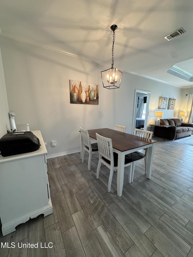 dining area featuring visible vents, baseboards, an inviting chandelier, wood tiled floor, and crown molding