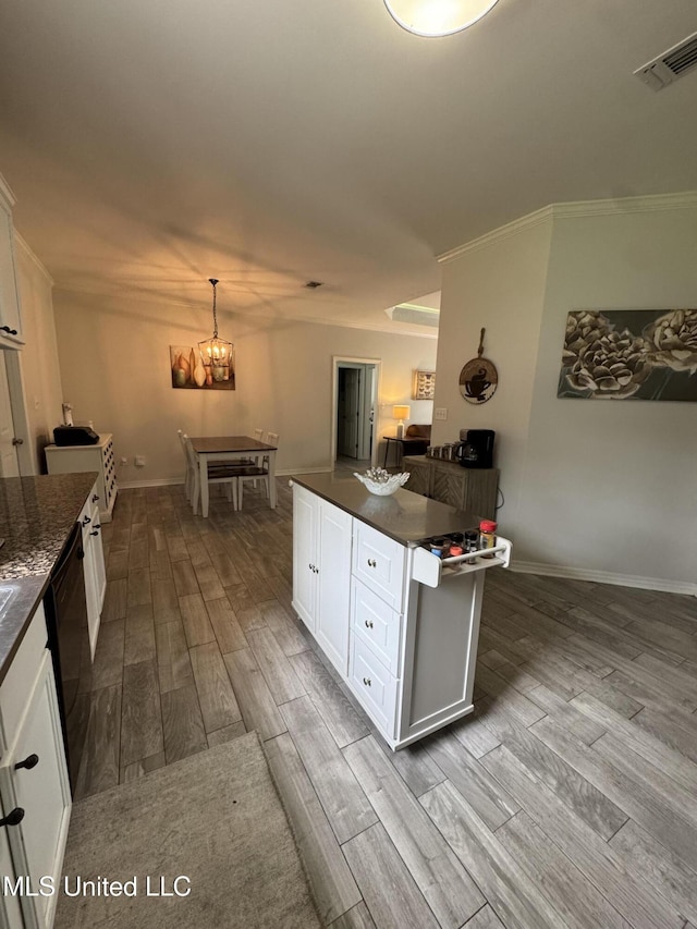 kitchen featuring visible vents, white cabinets, dishwasher, dark countertops, and wood finished floors