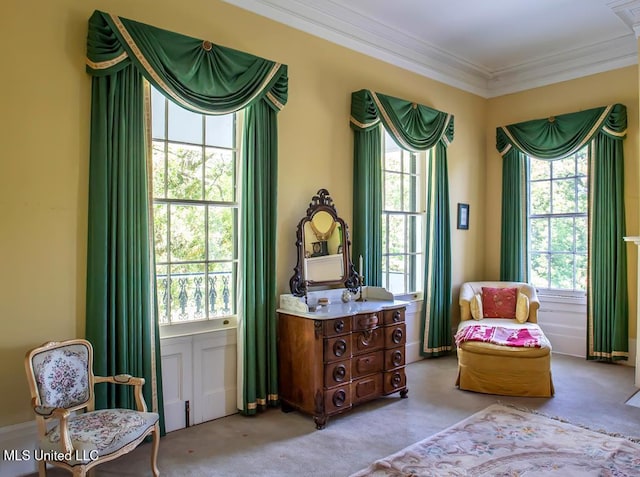 living area with ornamental molding, a wealth of natural light, and light colored carpet