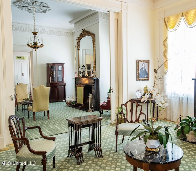 living area with carpet floors, a chandelier, a healthy amount of sunlight, and ornamental molding