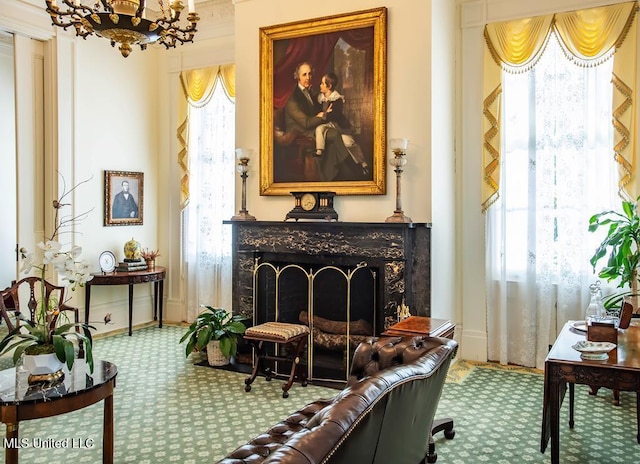 sitting room featuring a notable chandelier, a premium fireplace, and carpet