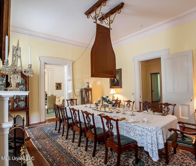 dining area featuring wood-type flooring and ornamental molding