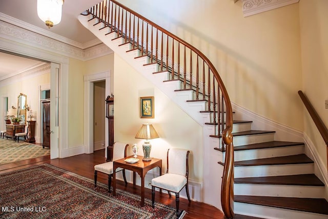 stairway featuring crown molding and wood-type flooring