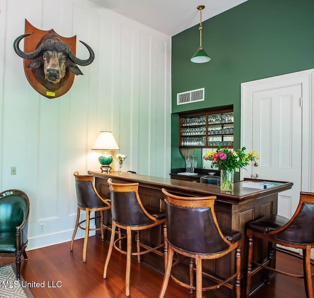 bar featuring dark hardwood / wood-style flooring and pendant lighting