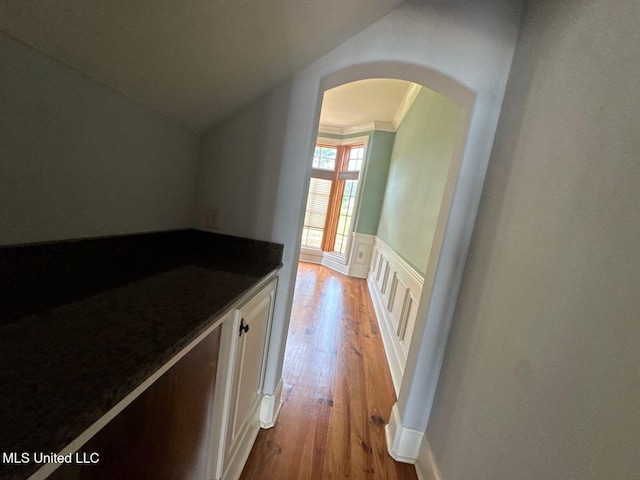 162 Lake Ridge Dr, Madison, MS 39110 - hallway with arched walkways, light wood-style floors, vaulted ceiling, and a wainscoted wall