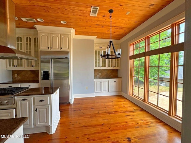 162 Lake Ridge Dr, Madison, MS 39110 - kitchen featuring stovetop, built in fridge, wall chimney exhaust hood, a chandelier, and wood ceiling