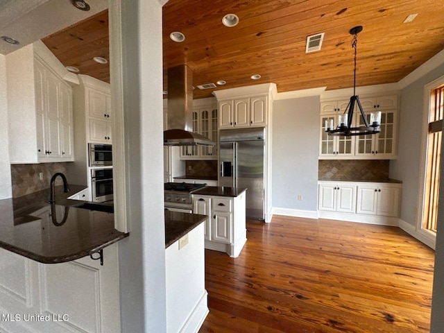162 Lake Ridge Dr, Madison, MS 39110 - kitchen featuring appliances with stainless steel finishes, wooden ceiling, dark countertops, a chandelier, and a peninsula
