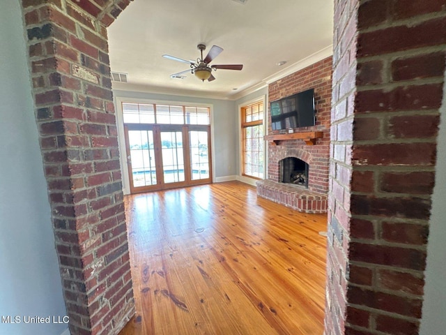 162 Lake Ridge Dr, Madison, MS 39110 - unfurnished living room with crown molding, a ceiling fan, wood finished floors, plenty of natural light, and a brick fireplace
