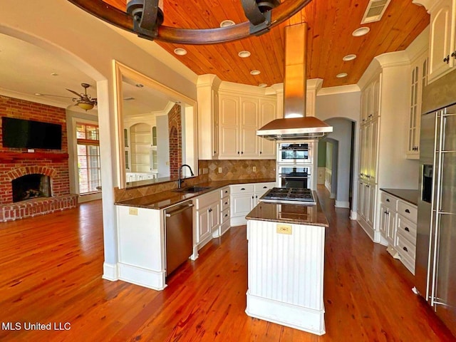 162 Lake Ridge Dr, Madison, MS 39110 - kitchen with a brick fireplace, stainless steel appliances, ceiling fan, a center island, and a sink