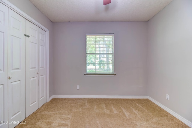 3217 N 2nd St, Ocean Springs, MS 39564 - unfurnished bedroom with carpet flooring, a textured ceiling, a closet, and baseboards