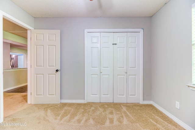 3217 N 2nd St, Ocean Springs, MS 39564 - unfurnished bedroom with carpet, a closet, baseboards, and a textured ceiling