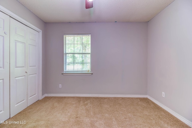 3217 N 2nd St, Ocean Springs, MS 39564 - unfurnished bedroom featuring carpet floors, baseboards, a textured ceiling, a closet, and a ceiling fan