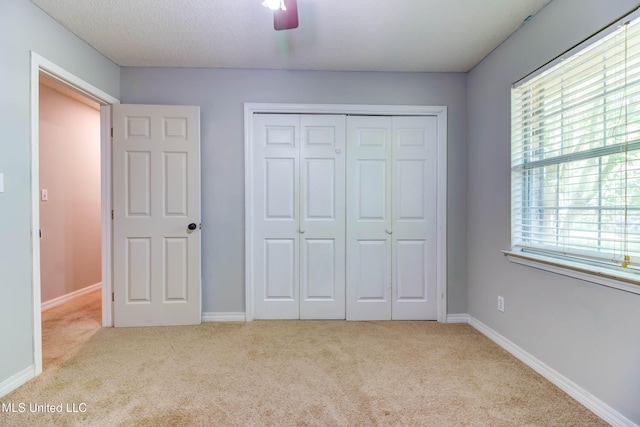3217 N 2nd St, Ocean Springs, MS 39564 - unfurnished bedroom with carpet flooring, multiple windows, a closet, and ceiling fan