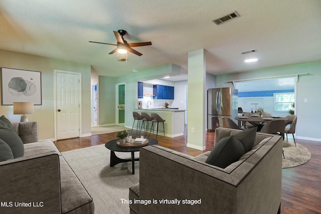 3217 N 2nd St, Ocean Springs, MS 39564 - living area featuring dark wood finished floors, a ceiling fan, a textured ceiling, and baseboards
