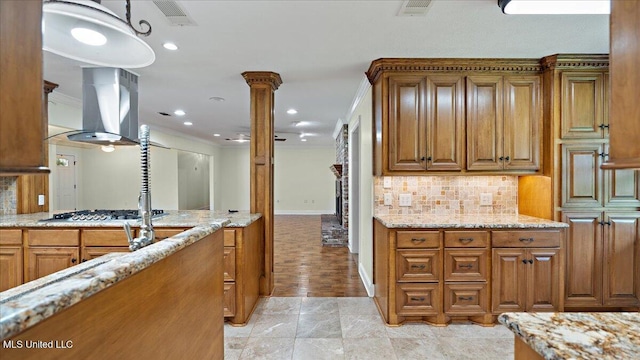 112 Eastgate Cir, Forest, MS 39074 - kitchen featuring brown cabinets, decorative columns, light stone countertops, crown molding, and decorative backsplash
