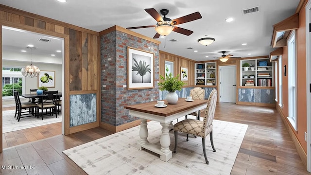 112 Eastgate Cir, Forest, MS 39074 - dining space with a ceiling fan, a chandelier, wood walls, wood finished floors, and built in shelves