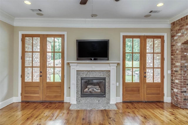 unfurnished living room with french doors, a healthy amount of sunlight, visible vents, and wood finished floors