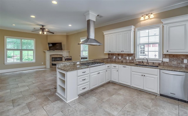 kitchen with island range hood, stainless steel appliances, a sink, open floor plan, and backsplash