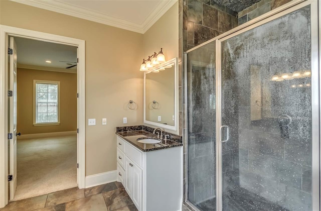 bathroom with a shower stall, baseboards, crown molding, and vanity