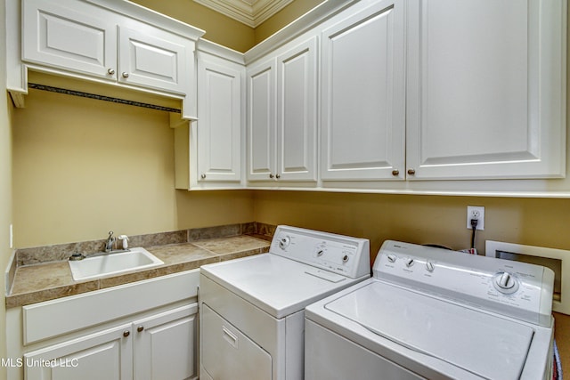 laundry room with cabinet space, a sink, and separate washer and dryer