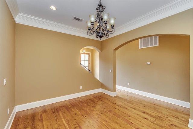 spare room with arched walkways, ornamental molding, and visible vents