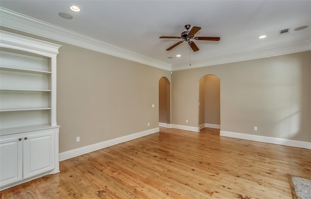 unfurnished room with arched walkways, baseboards, ceiling fan, ornamental molding, and light wood-type flooring