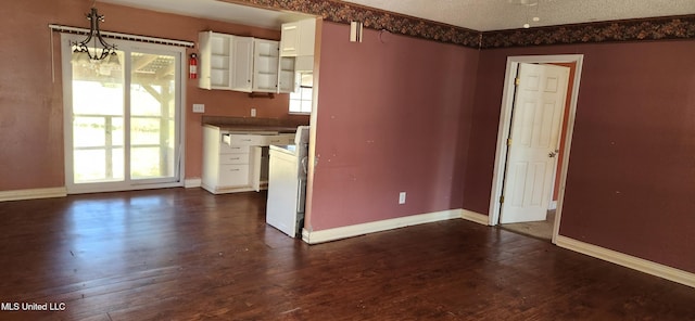 unfurnished room with a textured ceiling, dark hardwood / wood-style flooring, and plenty of natural light