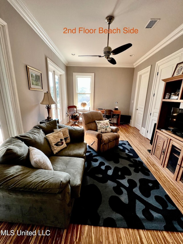 living room with ceiling fan, ornamental molding, and light wood-type flooring