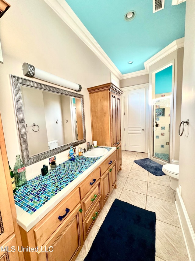 bathroom featuring toilet, vanity, walk in shower, crown molding, and tile patterned floors