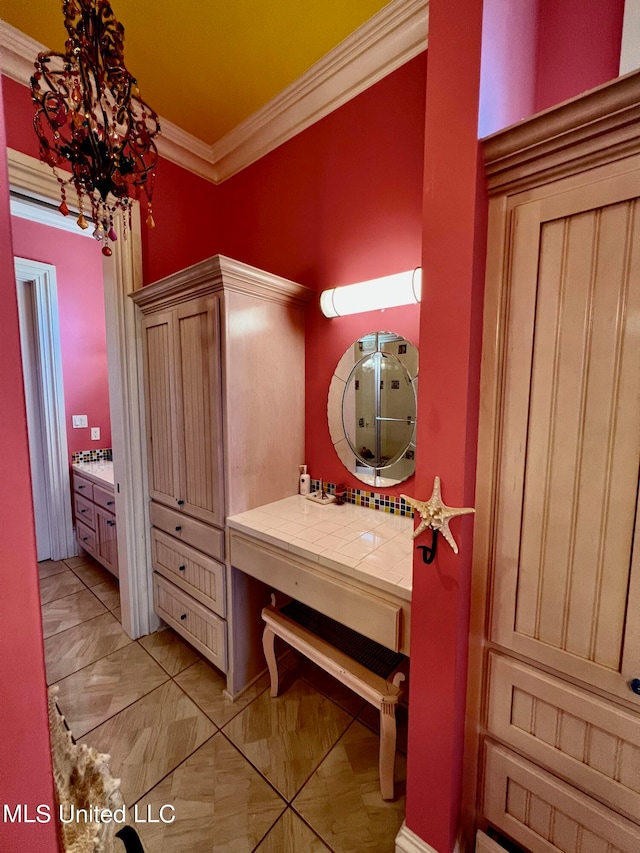 bathroom with crown molding, vanity, and a chandelier