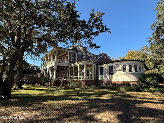 exterior space with a sunroom and a front yard