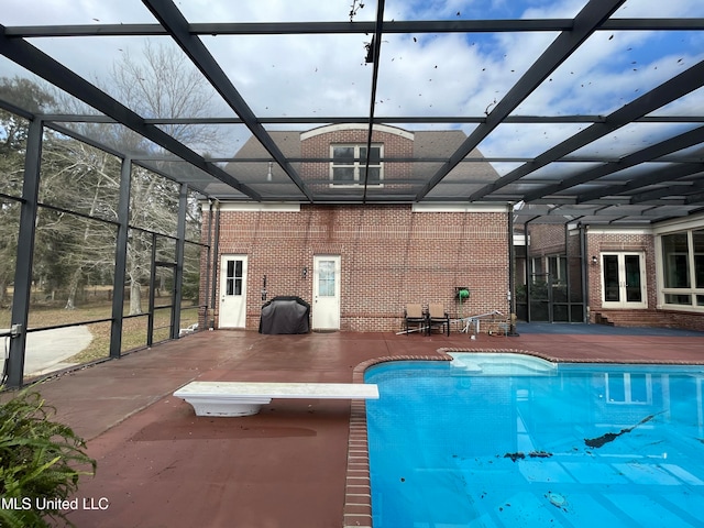 view of swimming pool with french doors, area for grilling, a diving board, a lanai, and a patio