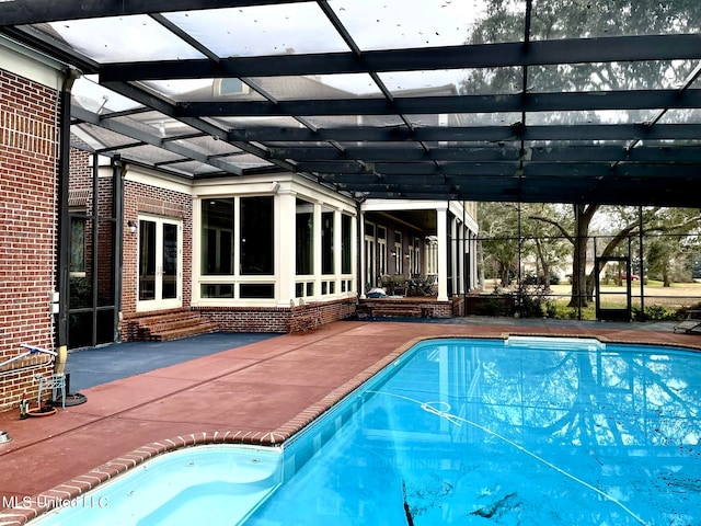 view of pool with a patio and glass enclosure