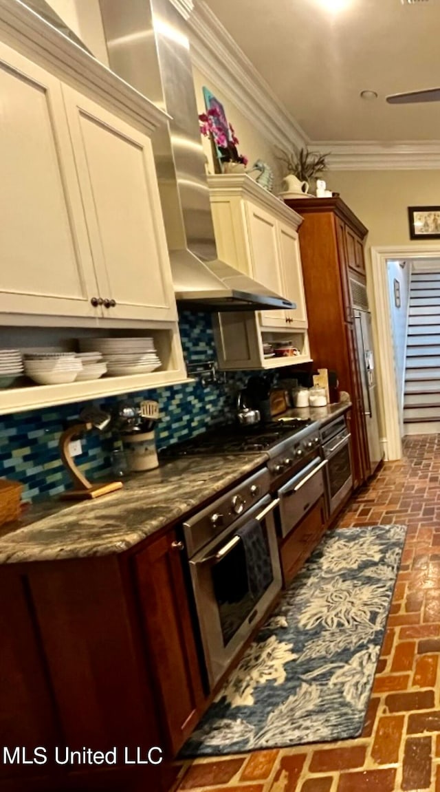 kitchen with stone counters, oven, decorative backsplash, crown molding, and high end fridge