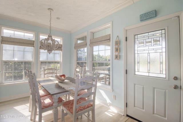 dining space with a notable chandelier, baseboards, crown molding, and light wood-style floors