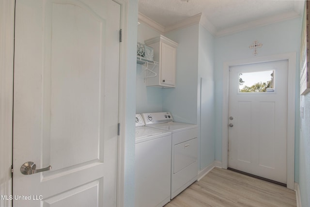 clothes washing area with light wood finished floors, cabinet space, washing machine and dryer, and ornamental molding