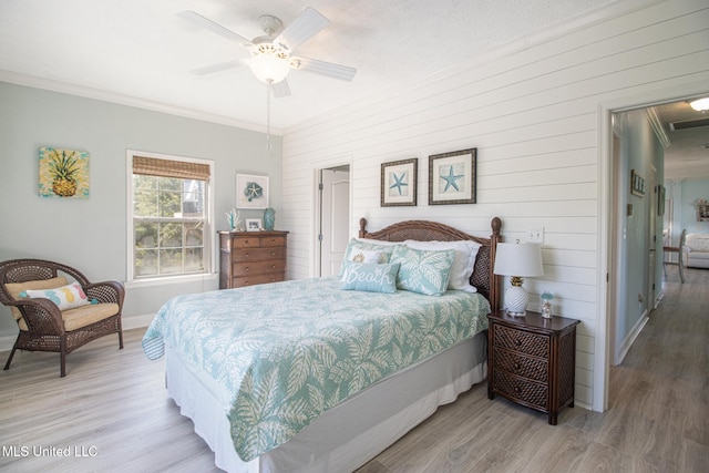 bedroom featuring visible vents, light wood-style floors, crown molding, baseboards, and ceiling fan