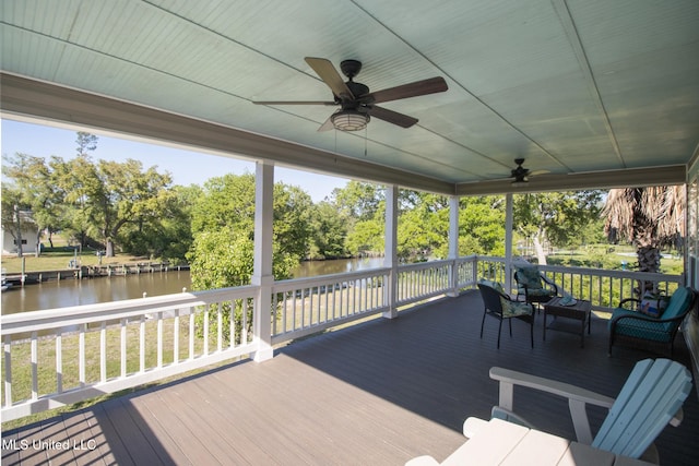 deck with a water view and ceiling fan