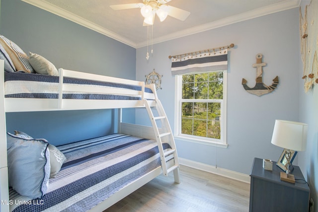 bedroom with ceiling fan, crown molding, baseboards, and wood finished floors