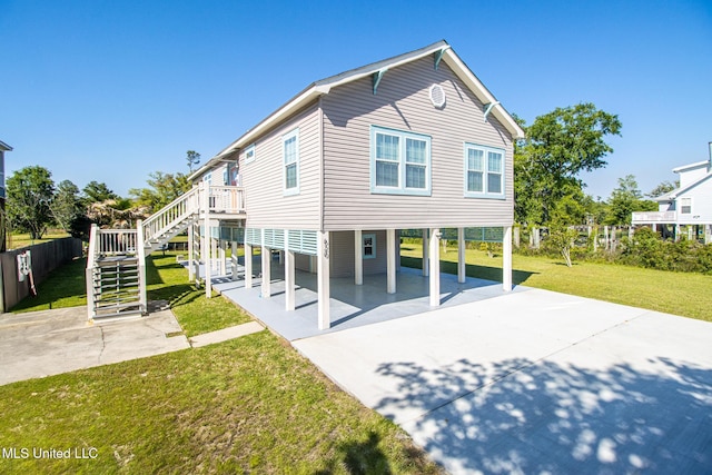 exterior space with a lawn, concrete driveway, a carport, stairs, and a patio area