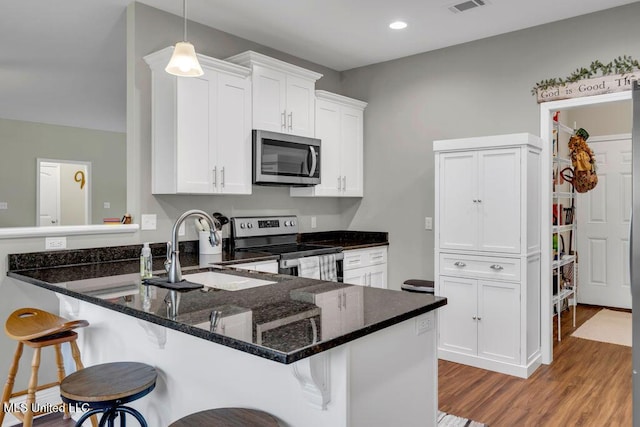 10714 Lilinoe Way, Diamondhead, MS 39525 - kitchen with a kitchen bar, light wood finished floors, stainless steel appliances, and a sink