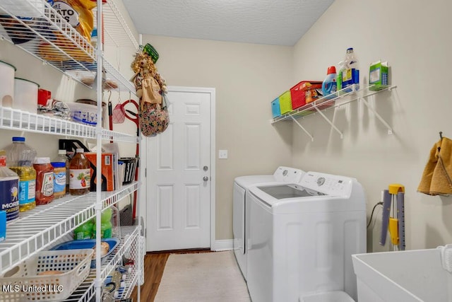 10714 Lilinoe Way, Diamondhead, MS 39525 - washroom with washing machine and clothes dryer, a sink, baseboards, wood finished floors, and laundry area