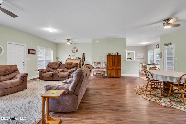 10714 Lilinoe Way, Diamondhead, MS 39525 - living area featuring dark wood-style flooring, a ceiling fan, and baseboards