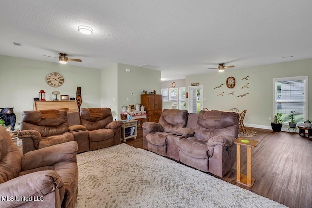 10714 Lilinoe Way, Diamondhead, MS 39525 - living room featuring wood finished floors, a healthy amount of sunlight, baseboards, and ceiling fan